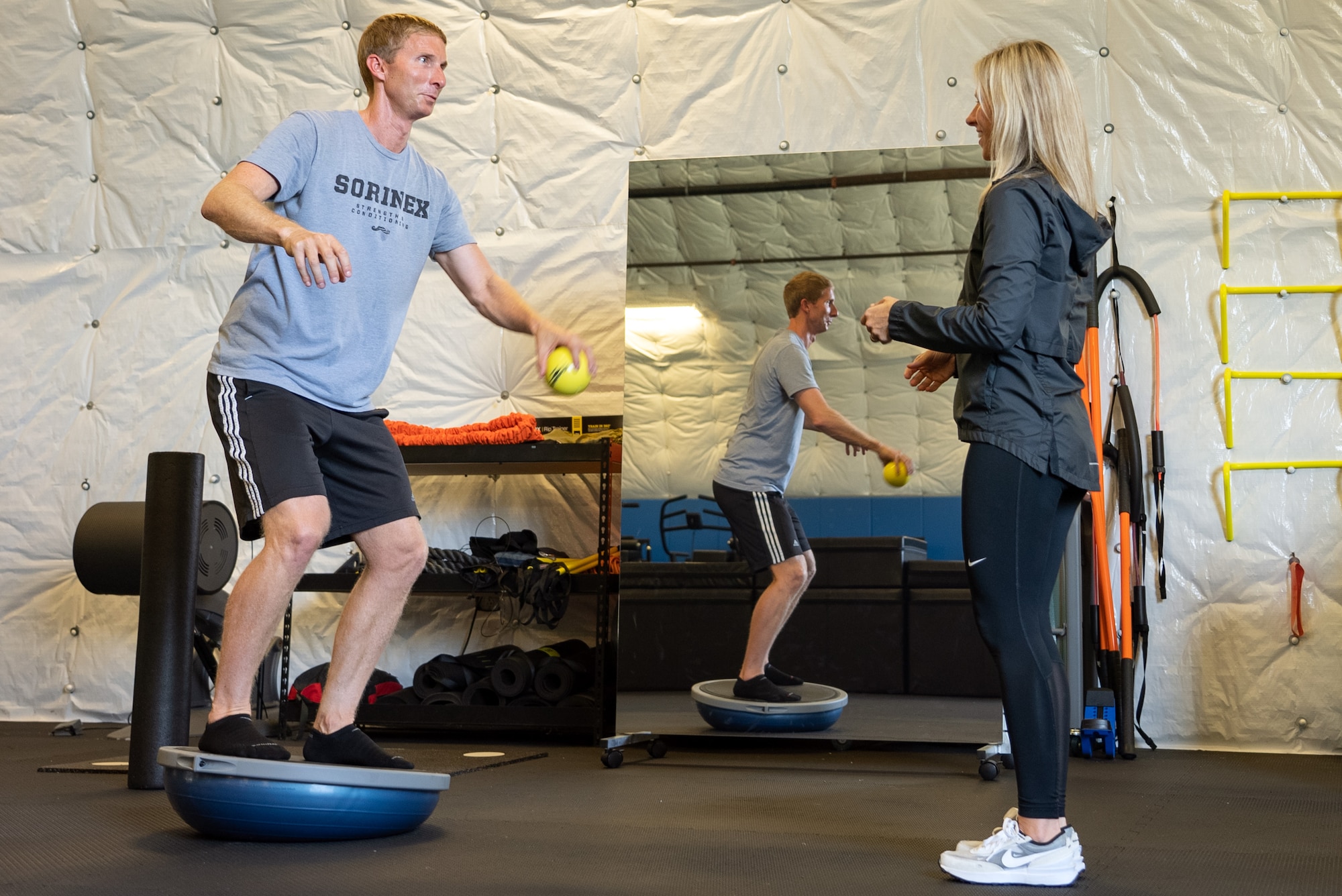 An athletic trainer performs a proprioceptive drill with another certified athletic trainer.