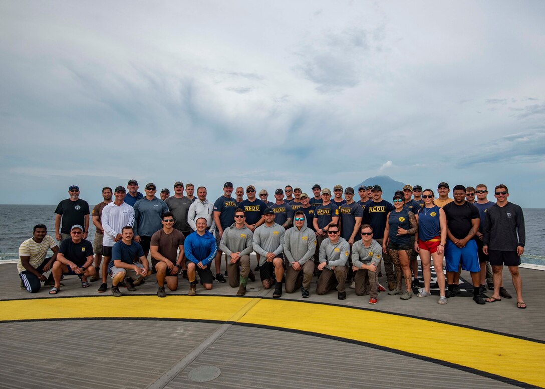 U.S. service members and civilians assigned to the Defense POW/MIA Accounting Agency (DPAA) and the Navy Experimental Diving Unit (NEDU) pose for a group photo as part of an underwater recovery mission in Hansa Bay, Papua New Guinea, March 09, 2023. DPAA personnel conducted an underwater excavation operation in an effort to find a U.S. aircraft crew lost over Papua New Guinea during World War II.