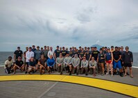 U.S. service members and civilians assigned to the Defense POW/MIA Accounting Agency (DPAA) and the Navy Experimental Diving Unit (NEDU) pose for a group photo as part of an underwater recovery mission in Hansa Bay, Papua New Guinea, March 09, 2023. DPAA personnel conducted an underwater excavation operation in an effort to find a U.S. aircraft crew lost over Papua New Guinea during World War II.