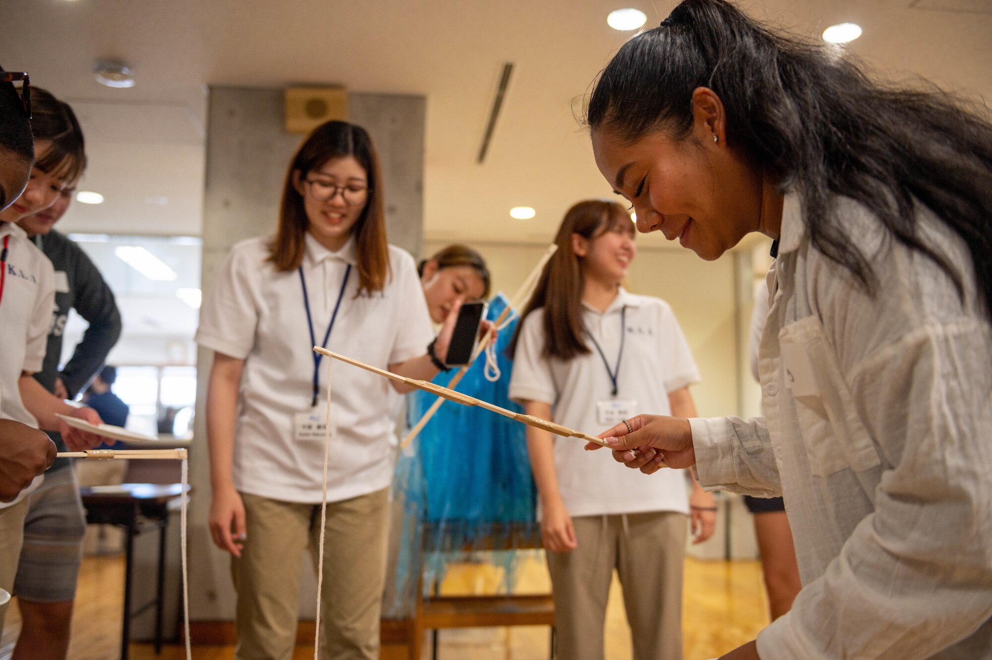 Airmen and Japanese students play a carnival fishing game