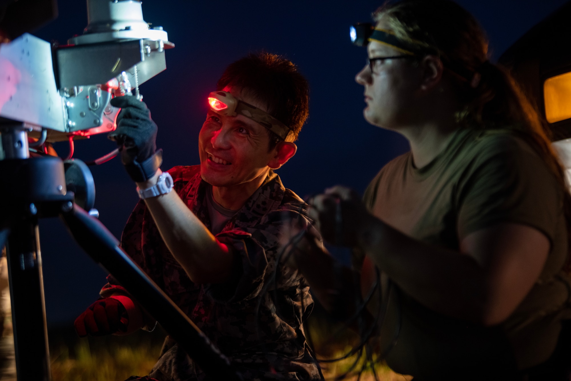 U.S. Air Force Airman alongside JASDF Airman assembling a Transportable Transponder Landing System.