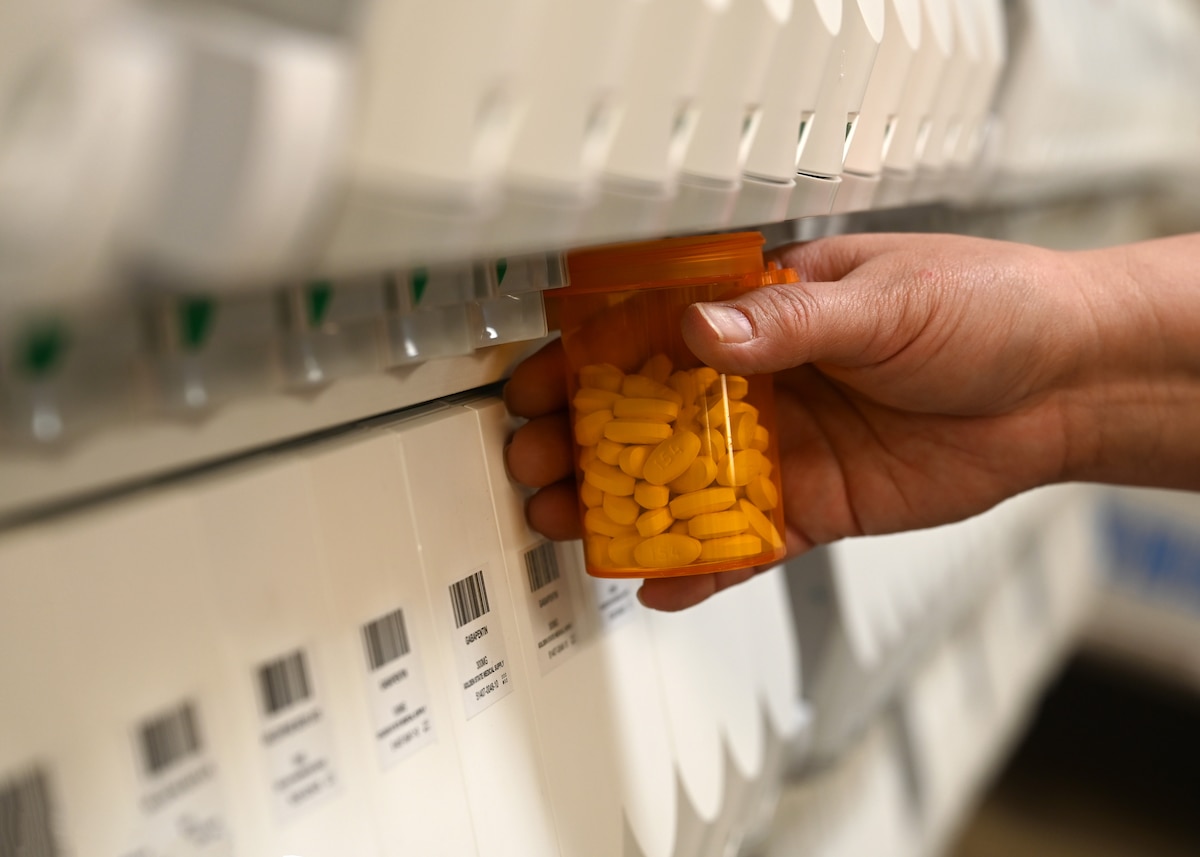 Pharmacy technician fills a prescription bottle