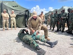 Photo: U.S. Air Force Tech. Sgt. Scott Palelei, a tactical air control party specialist with the 137th Special Operations Wing, Oklahoma Air National Guard, applies a tourniquet to a member of the Guyana Defense Force during tactical combat casualty training held at Camp Seweyo, Guyana, for TRADEWINDS23 Exercise July 16, 2023. TRADEWINDS is initiated and formulated as part of the Caribbean Basin Initiative, which allows participating nations to forge enduring relationships that will improve security capabilities through the exchange of knowledge and expertise. (U.S. Air National Guard photo courtesy of Senior Airman Richie Thammavongsa)
