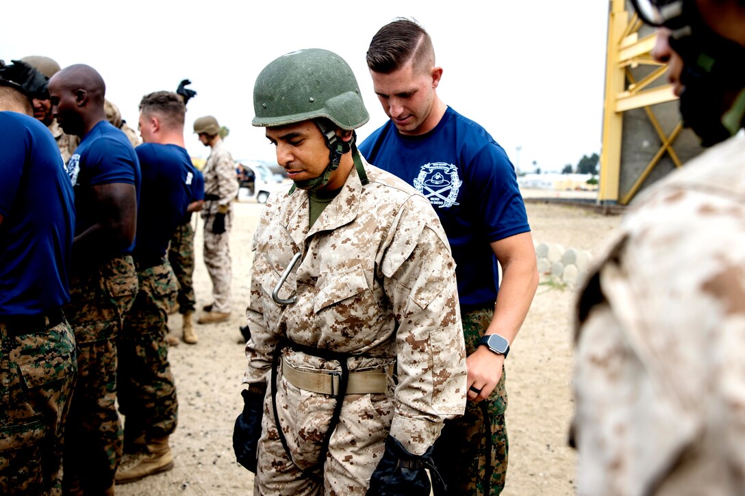 U.S. Marine Pvt. Robert Garcia, with Mike Company, 3rd Recruit Training Battalion, gets his harness fastened before conducting the rappel tower at Marine Corps Recruit Depot San Diego, July 21, 2023