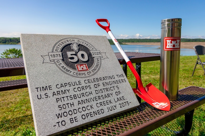 A stone tablet was placed overtop the time capsule after it was buried at Woodcock Creek Lake in Saegertown, Pennsylvania, July 14, 2023. Community leaders and Corps of Engineers employees gathered on a summer morning to celebrate Woodcock Creek Dam’s 50th anniversary. The corps built Woodcock Creek Dam to reduce floods along the French Creek, saving communities such as Saegertown and Meadville from catastrophic flooding year after year and has prevented more than $38 million in flood damages since its construction in 1973. The time capsule will be opened at the dam’s 100th celebration in 2073. (U.S. Army Corps of Engineers Pittsburgh District photo by Andrew Byrne)