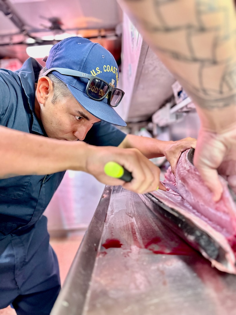 Petty Officer 1st Class Ikaika Ruiz prepares a wahoo for sashimi aboard the USCGC Oliver Henry (WPC 1140) while underway off the Republic of Palau on April 1, 2023. Originally from Hawaii, Ruiz is an engineer aboard the ship specializing as an electrician. (U.S. Coast Guard photo by Chief Warrant Officer Sara Muir)