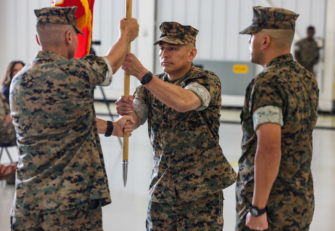 U.S. Marine Corps Col. Christopher L. Bopp, outgoing commanding officer for Marine Corps Base (MCB) Camp Blaz, left, passes the unit colors to Col. Ernest Govea, incoming commanding officer for MCB Camp Blaz, center, during a change of command ceremony at Andersen Air Force Base, Guam, July 10, 2023. Bopp relinquished command of Camp Blaz to Govea after serving as the commanding officer since May of 2021. The change of command ceremony is an honored tradition, which signifies the transfer of command responsibility from one commander to another. (U.S. Marine Corps photo by Lance Cpl. Garrett Gillespie)