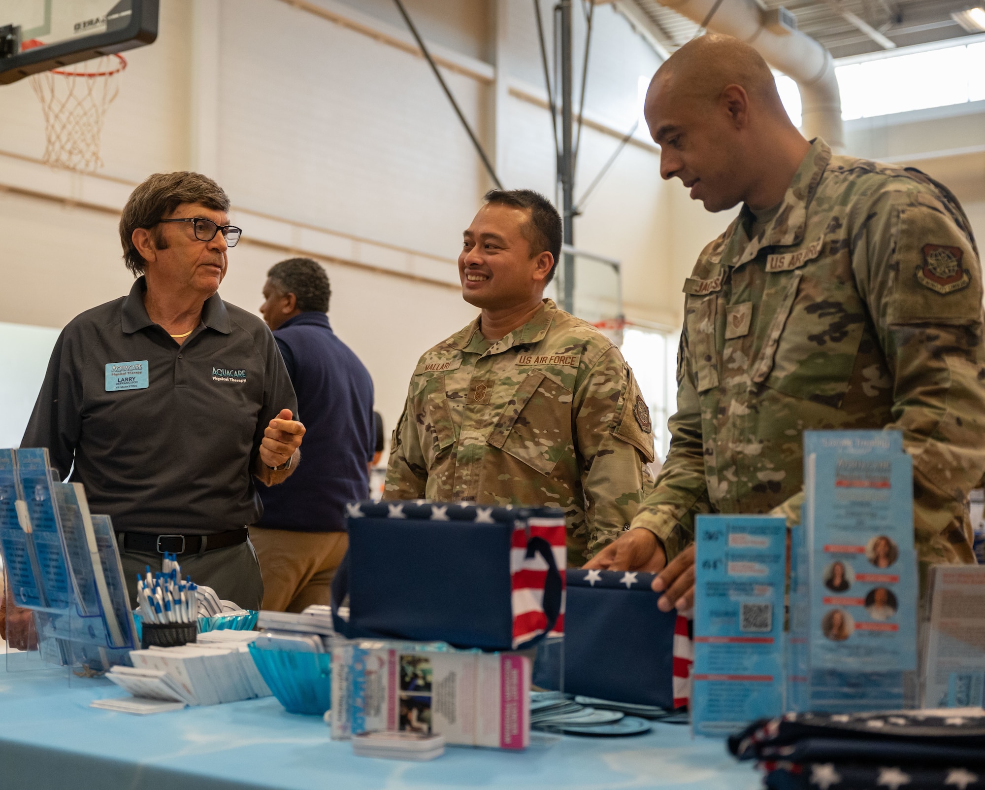 Larry DeFrancisco, left, Aquacare Physical Therapy marketing vice president, speaks with Chief Master Sgt. Darwin Mallari, center, 436th Force Support Squadron superintendent, and Tech. Sgt. Layne Jackson, right, 436th Airlift Wing Equal Opportunity noncommissioned officer in charge, during the 436th FSS Health and Wellness Fair at Dover Air Force Base, Delaware, July 26, 2023. The event featured various military and civilian organizations focused on providing health resources to Airmen. (U.S. Air Force photo by Senior Airman Cydney Lee)