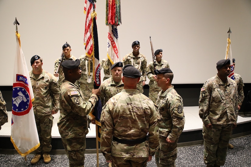 Soldiers in uniform perform the passing of the brigade guidon during a change of command ceremony.