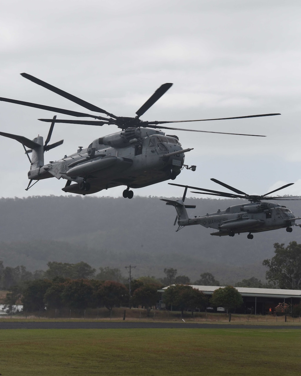 Two military aircraft land in a field.