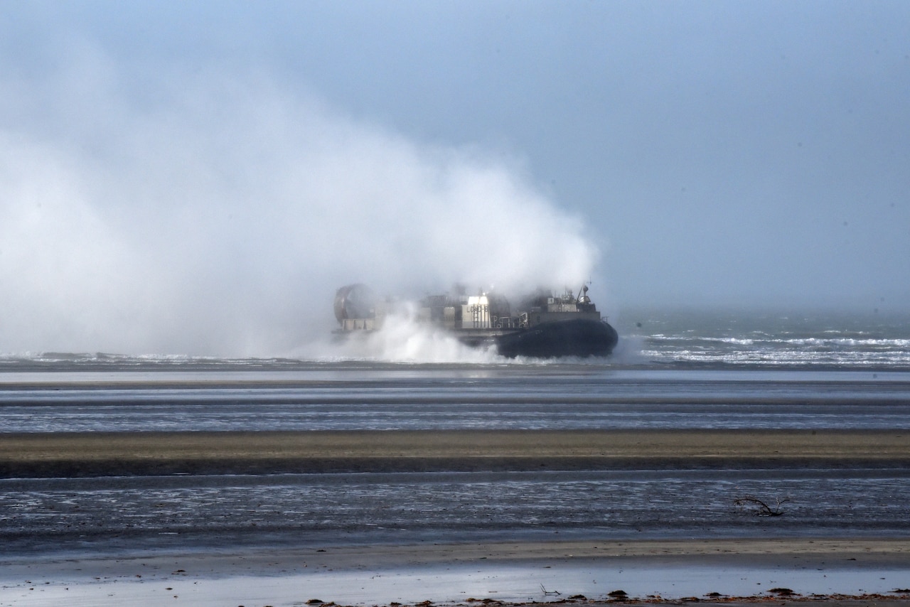 A landing craft approaches a beach.