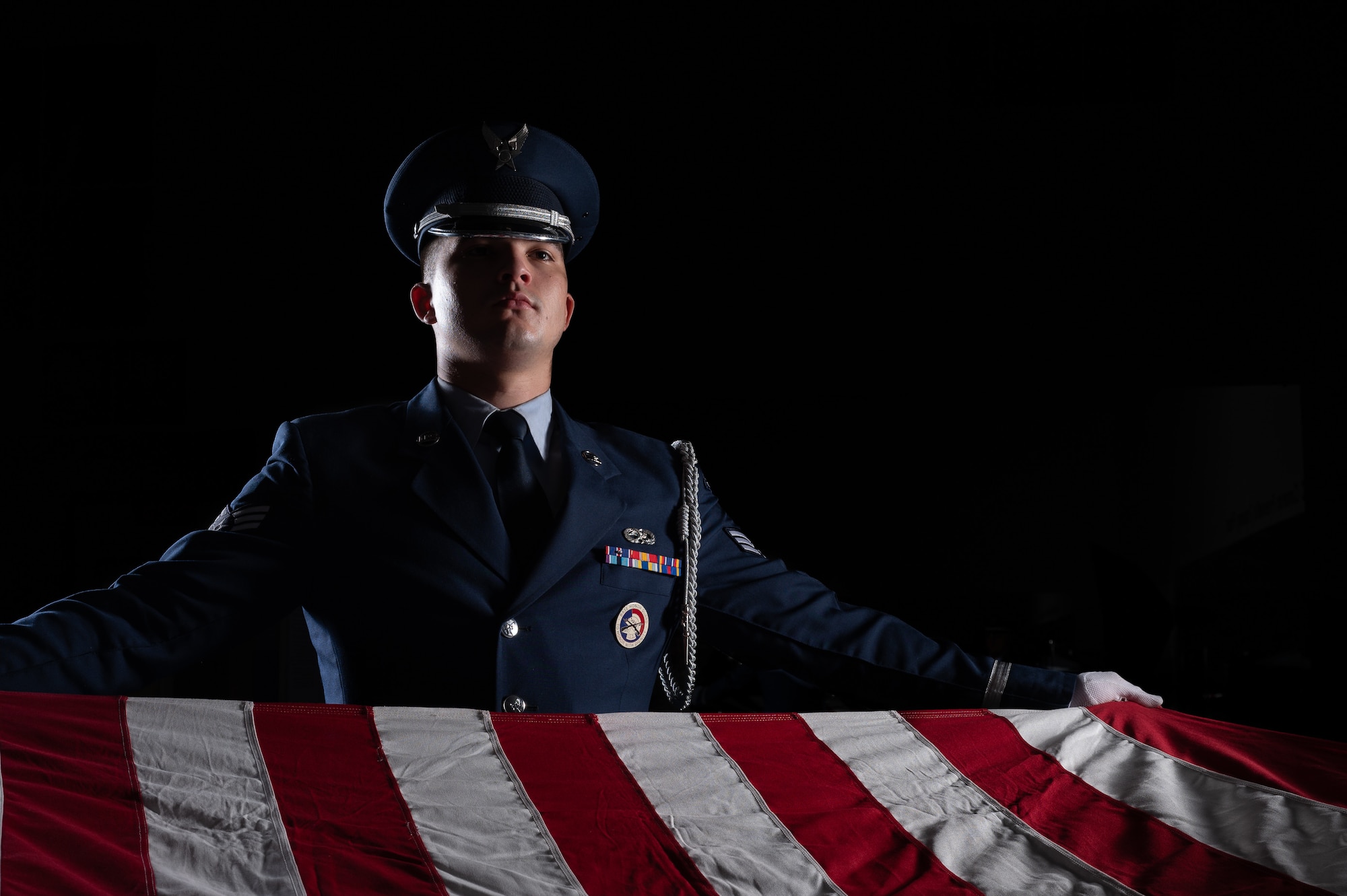 Senior Airman Tristan Henson, 436th Maintenance Squadron crew chief, practices flag folding at the Dover Air Force Base Honor Guard facility at Dover Air Force Base, Delaware, July 25, 2023. Members of the Honor Guard are employed in a variety of team sizes, ranging from a simple two-Airman flag-folding detail, to a 20-Airman funeral detail that includes pallbearers, colors, a bugle player and a firing party for a 21-gun salute. (U.S. Air Force by Mauricio Campino)