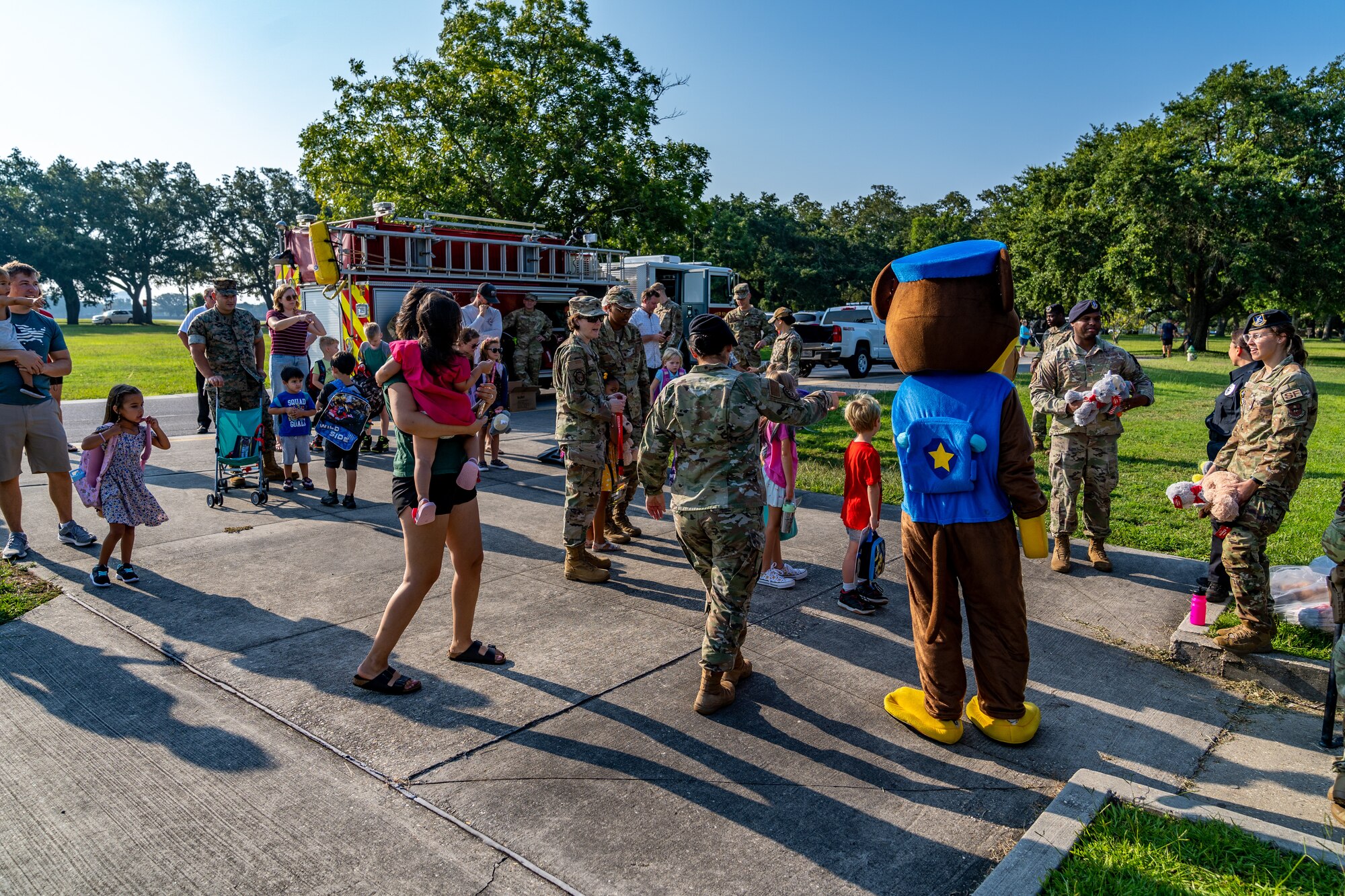 Sparky, Keesler Fire Department mascot, and Chase, 81st Security Forces Squadron mascot, welcome kids to their first day of school at Keesler Air Force Base, Mississippi, July 27, 2023.