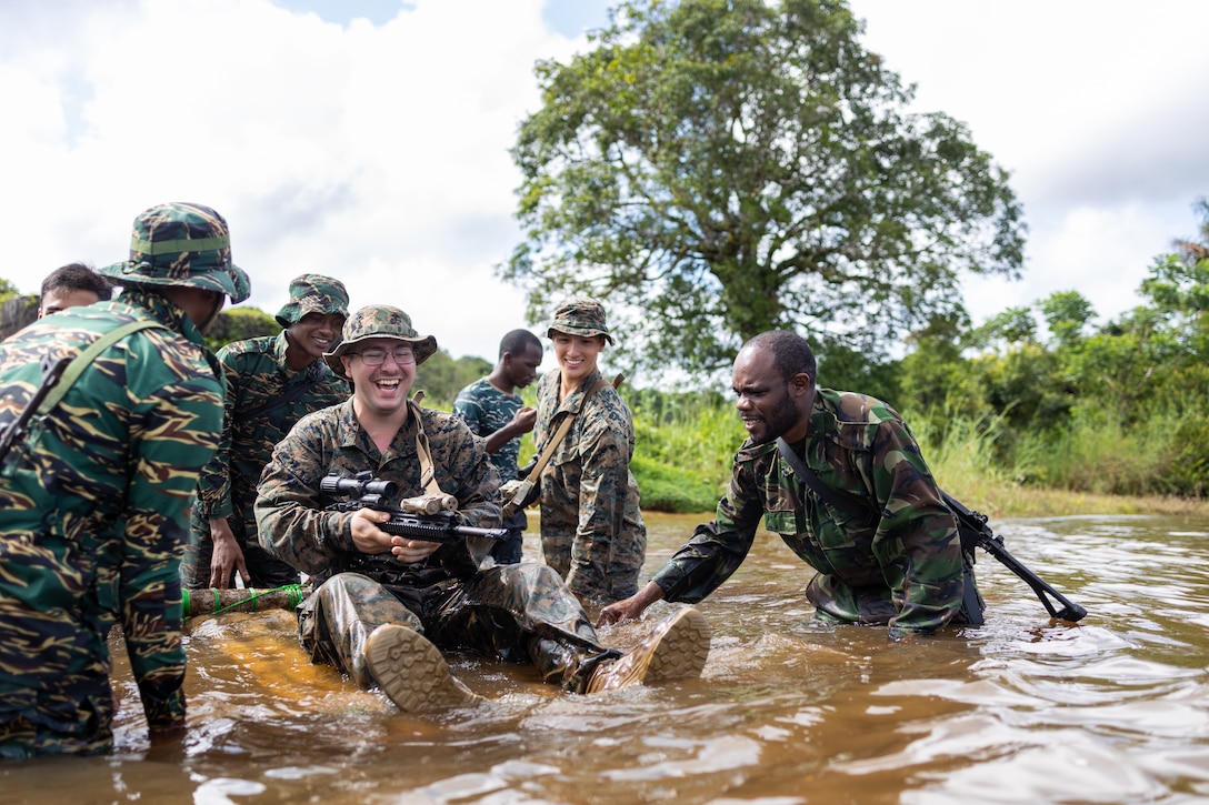 U.S. Marines with Fox Company, 2nd Battalion, 25th Marine Regiment, 4th Marine Division, Marine Forces Reserve, military members from Guyana Defence Force, use improvised flotation devices using different techniques taught in Jungle Amphibious Training School during Tradewinds 2023 at Jungle Area Training Site, Guyana, July 20, 2023. Tradewinds is a U.S. Southern Command-sponsored exercise designed to strengthen partnerships and interoperability, promote human rights, as well as increase all participants' training capacity and capability to mitigate, plan for and respond to crises and security threats.