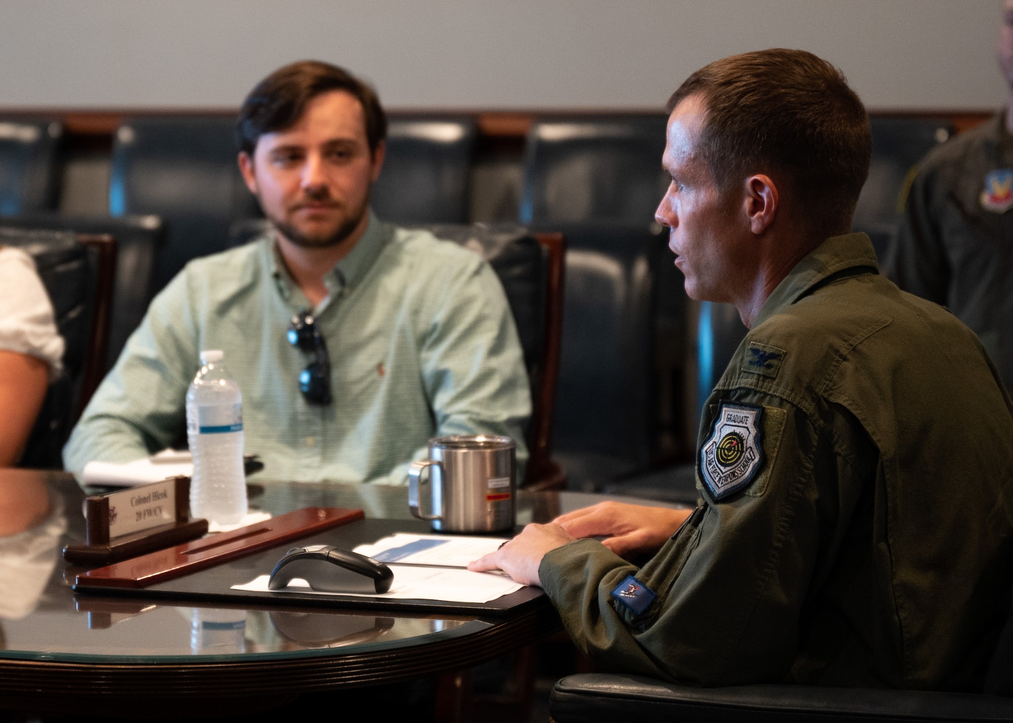Two individuals have a discussion in a darkened conference room at Shaw Air Force Base, S.C.