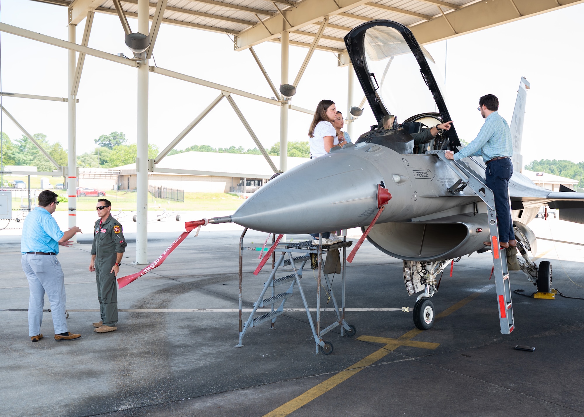 Multiple individuals stand near an F-16C Fighting Falcon under a hangar at Shaw Air Force Base, S.C.