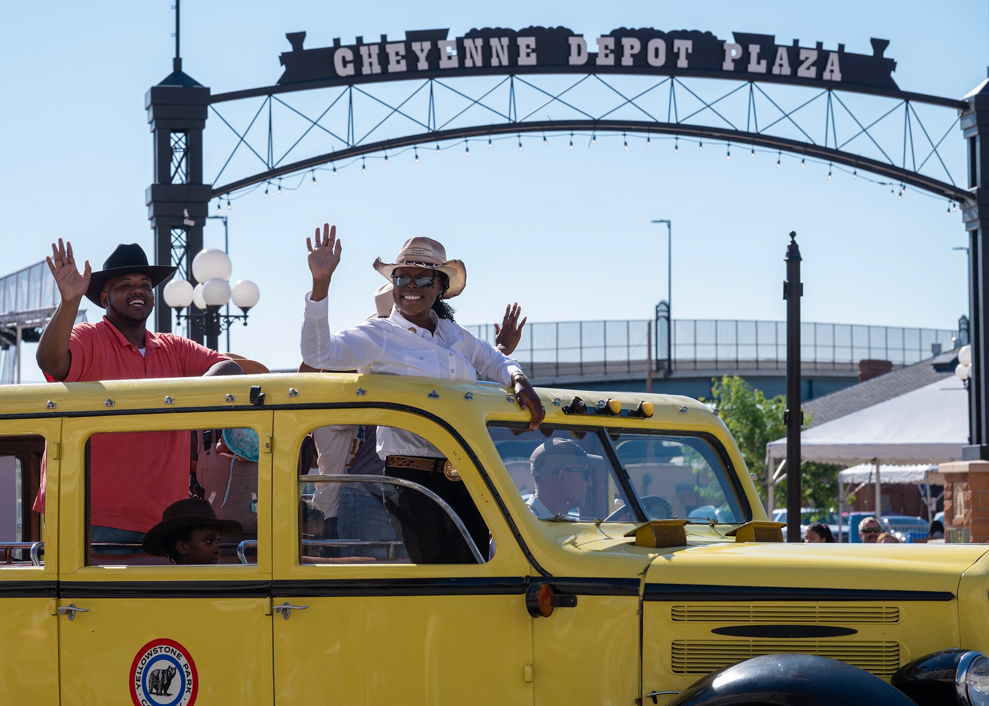 Command Chief waving at crowd from a yellow tour bus