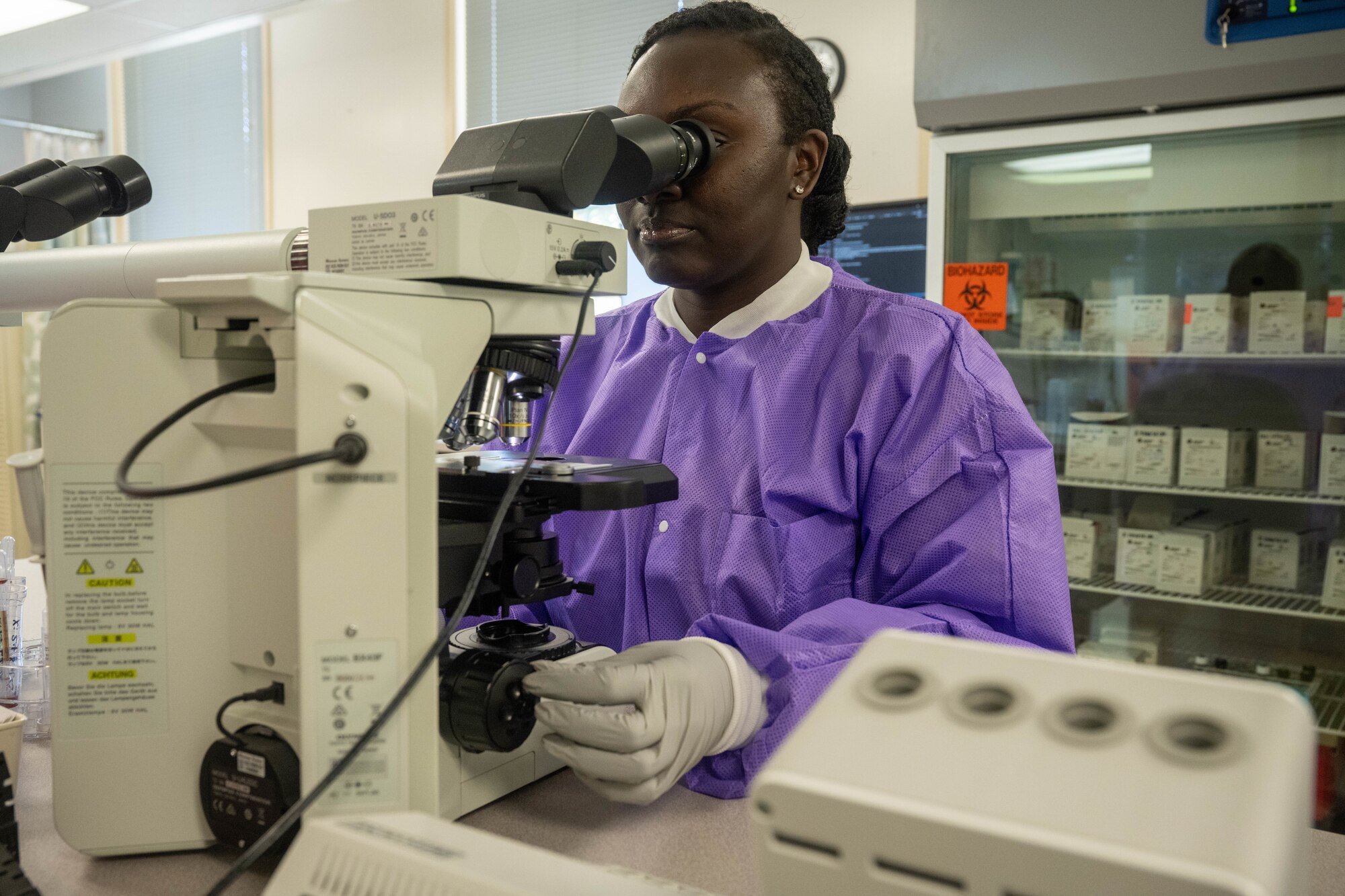 Staff Sgt. Brittany Brown, 15th Medical Group Diagnostics and Therapeutics flight chemistry Non-commissioned officer in charge, looks at a sample in a microscope at Joint Base Pearl Harbor-Hickam, Hawaii, July 20, 2023. The laboratory recently earned a perfect score on the civilian accreditation from the College of American Pathologists, it ensures the laboratory is producing accurate and reliable test results and ensures accurate patient diagnosis and care. (U.S. Air Force photo by Senior Airman Makensie Cooper)