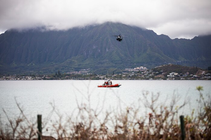 U.S. Military personnel with the Marine Corps Base Hawaii Provost Marshal’s Office and Waterfront Operations post security on a marine vessel, while a CH-53 Super Stallion attached to Marine Heavy Helicopter Squadron 463 flies overhead during Lethal Breeze 2021, MCBH, Aug. 10, 2021. Lethal Breeze is an exercise that exhibits the base’s ability to effectively respond, communicate and coordinate operations across multiple locations during a dynamic incident. (U.S. Marine Corps photo by Lance Cpl. Brandon Aultman)