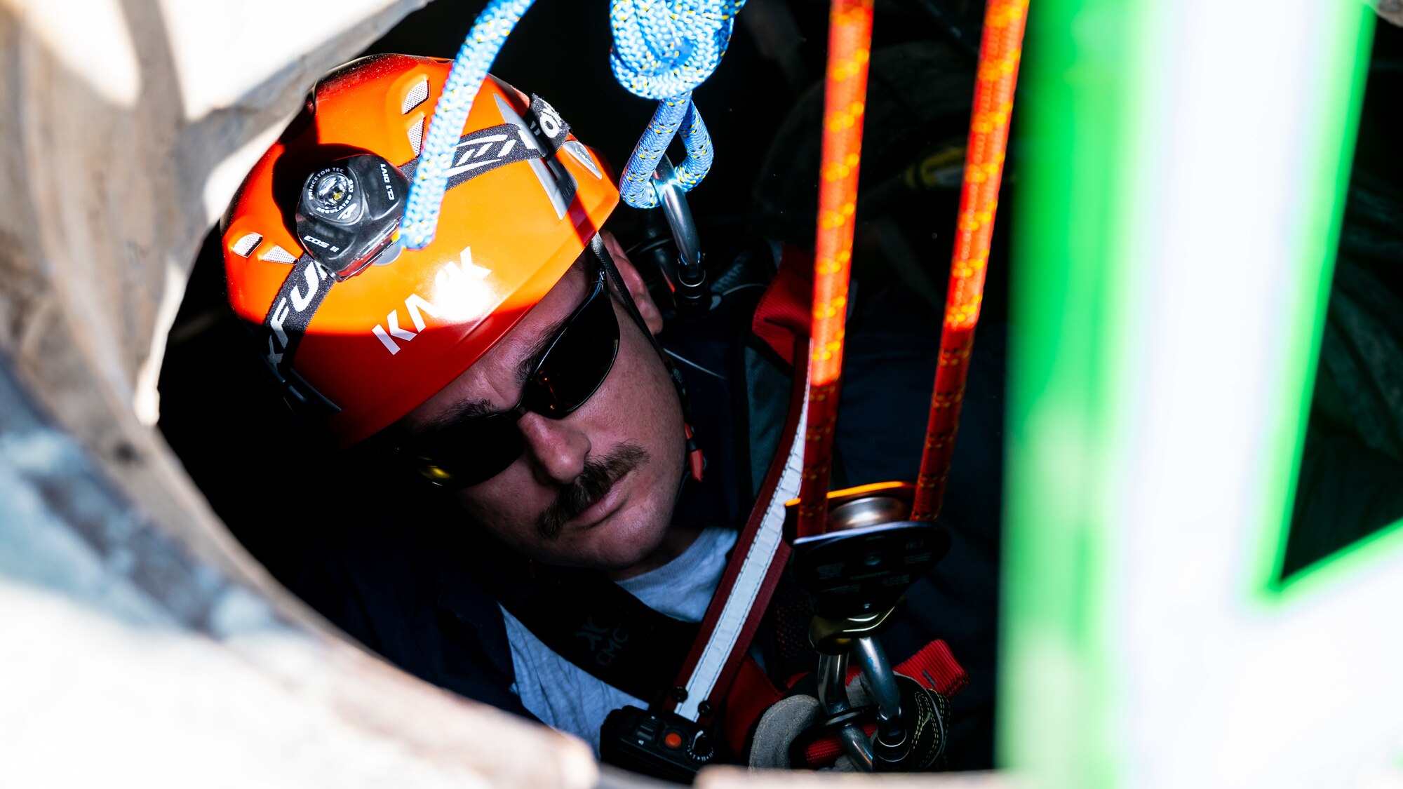 U.S. Air Force Tech. Sgt. Michael Cassaday, fire station captain at the 386th Expeditionary Civil Engineer Squadron, is lowered into a manhole during confined-space training at Ali Al Salem Air Base, Kuwait, July 25, 2023. This confined-space training allowed for the U.S. and our Canadian partners to share their knowledge and expertise, thus reducing the risks associated with confined-space operations for all. (U.S. Air Force photo by Staff Sgt. Kevin Long)