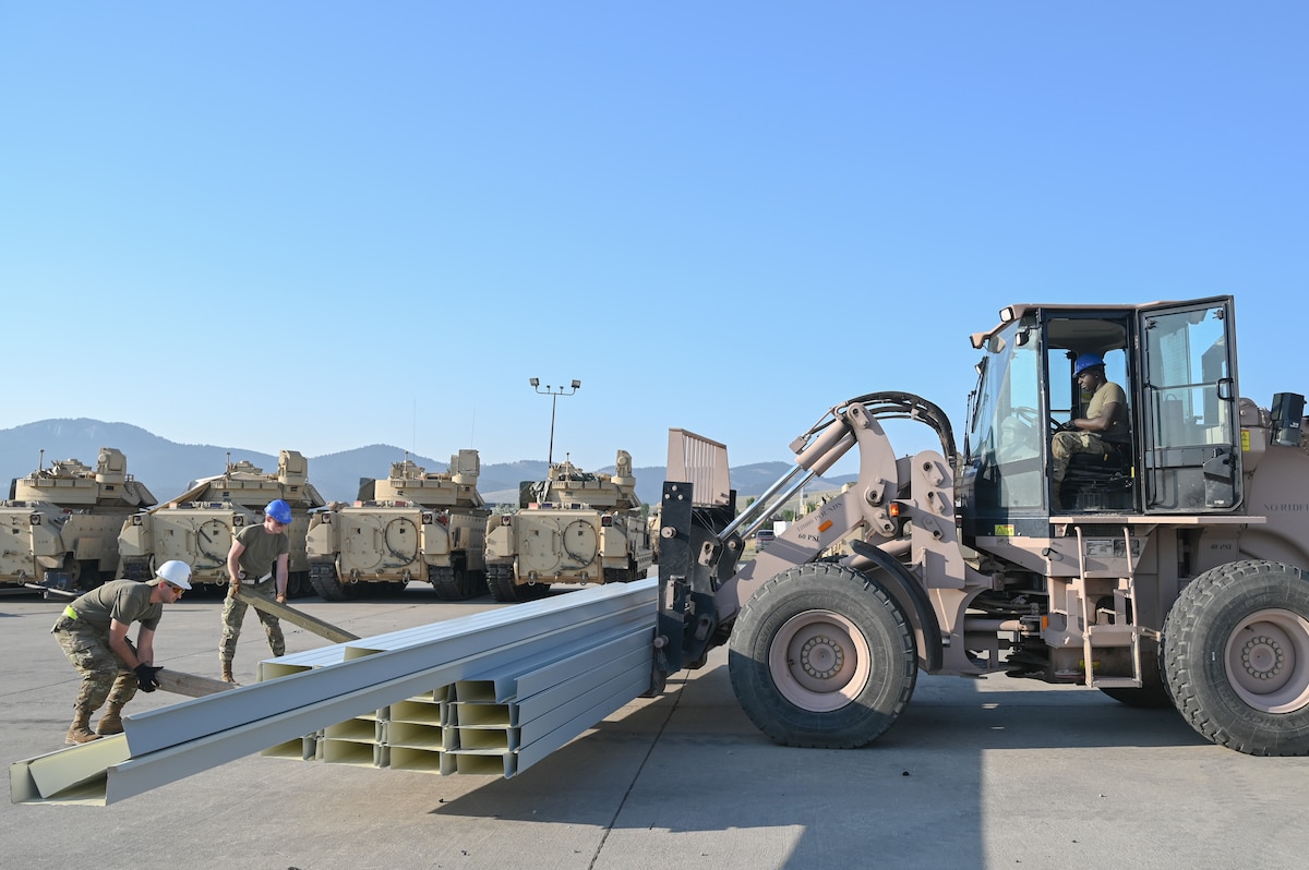 Airmen with the 131st Civil Engineer Squadron load a forklift with building materials to transport onto a construction site at Fort William Henry Harrison, Montana, July 25, 2023. The 131st CES will build a M1 Abrams tank storage facility for the Montana National Guard to remedy storage deficiencies. (U.S. Air National Guard photo by Airman 1st Class Phoenix Lietch)