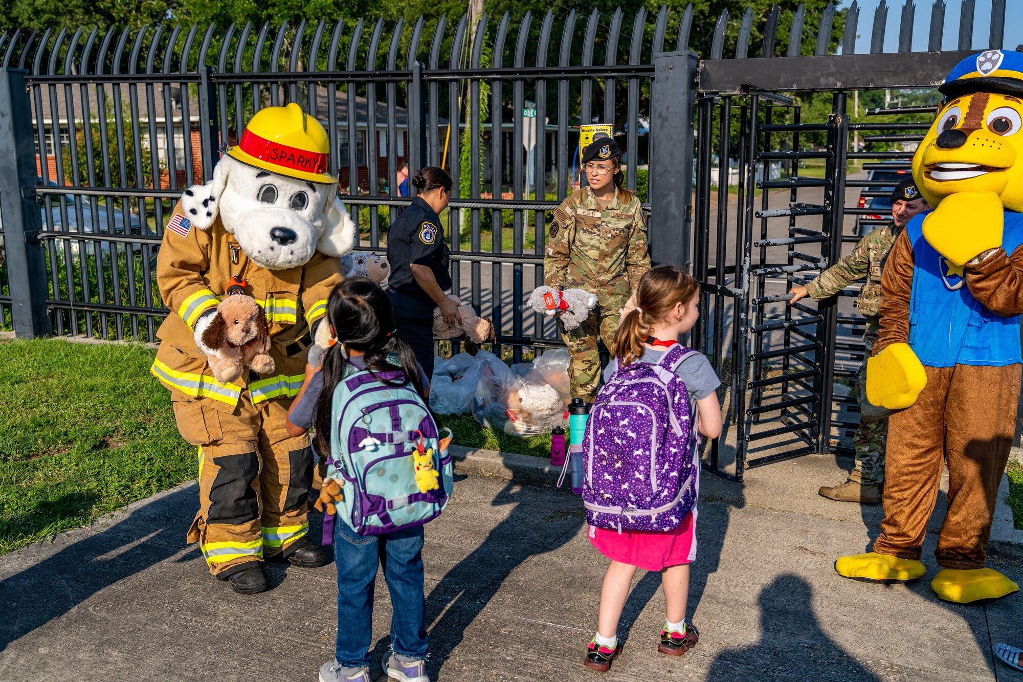 Sparky, Keesler Fire Department mascot, and Chase, 81st Security Forces Squadron mascot, welcome kids to their first day of school at Keesler Air Force Base, Mississippi, July 27, 2023.