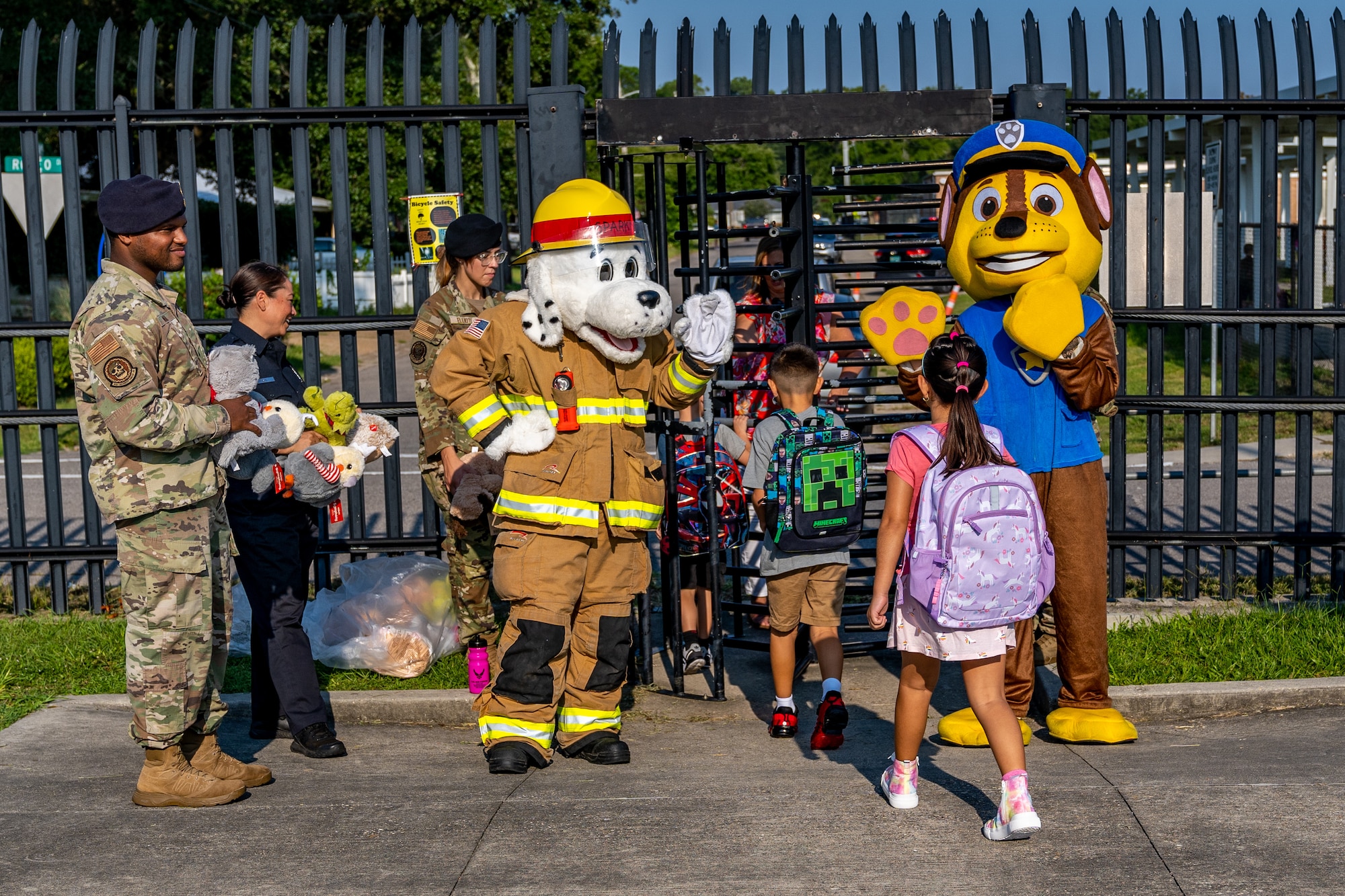 Sparky, Keesler Fire Department mascot, and Chase, 81st Security Forces Squadron mascot, welcome kids to their first day of school at Keesler Air Force Base, Mississippi, July 27, 2023.