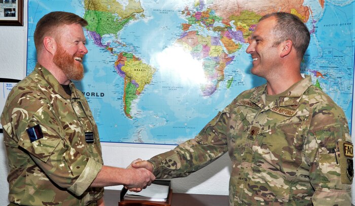 A photo of two military members shaking hands.
