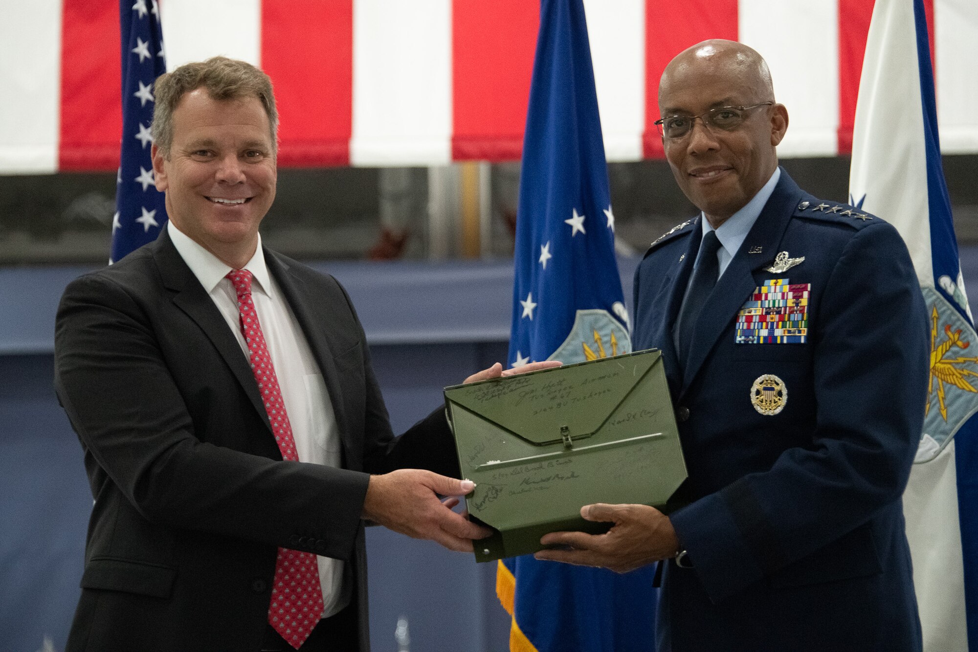 Rob Collings, Collings Foundation’s executive director, and U.S. Air Force Chief of Staff Gen. CQ Brown, Jr., exchange a map signed by the Tuskegee Airmen during the PT-17 Stearman Aircraft Exchange ceremony at Joint Base Andrews, Md., July 26, 2023. Brown became an honorary Tuskegee Airman in August 2021. (U.S. Air Force photo by Senior Airman Tyrone Thomas)