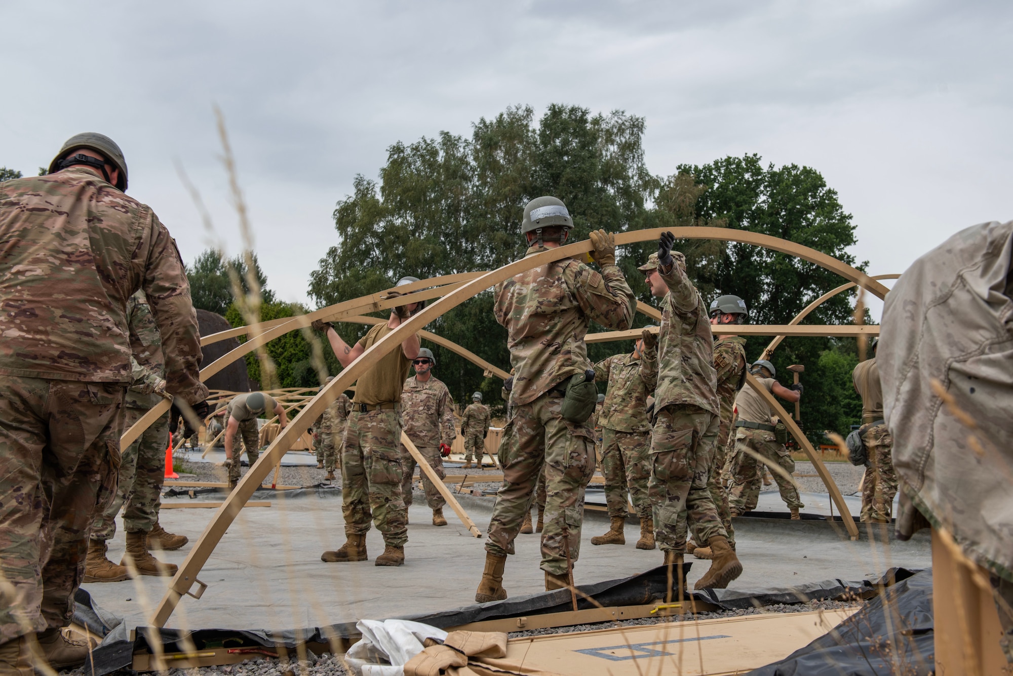 Multiple Airmen work together to set up a tent