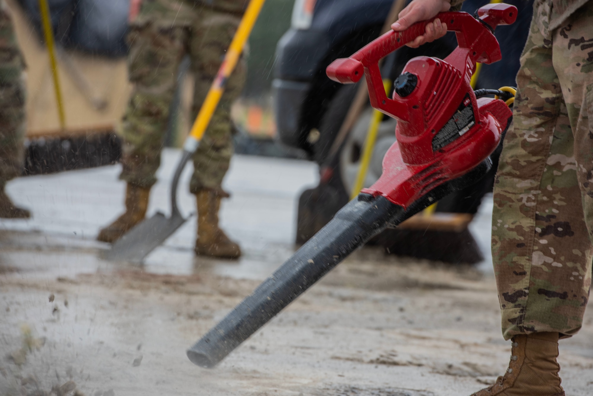 Airman uses a red leaf blower