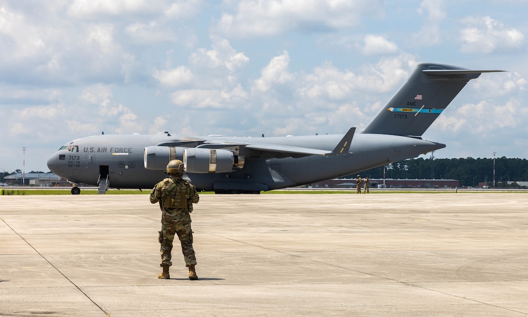 A U.S. Airman with Dover Air Mobility Command guides a C-17 Globemaster III during Exercise Razor Talon on Marine Corps Air Station (MCAS) Cherry Point, North Carolina, July 25, 2023. During this exercise, fighter jets, mobility aircraft, and contingency response assets from the Army, Marine Corps, and Air Force join forces to defend MCAS Cherry Point against simulated airborne threats. (U.S. Marine Corps photo by Cpl. Jade Farrington)