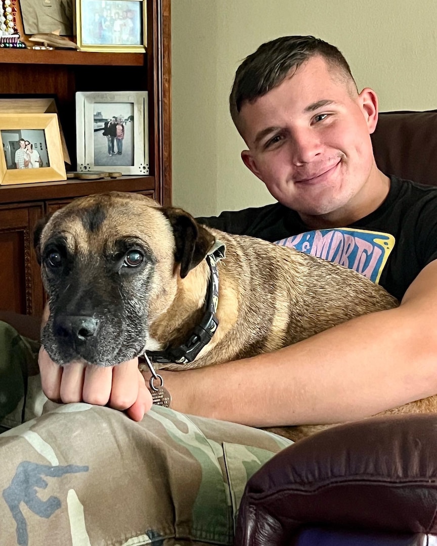 Young Marine sitting in a chair with a dog in his lap