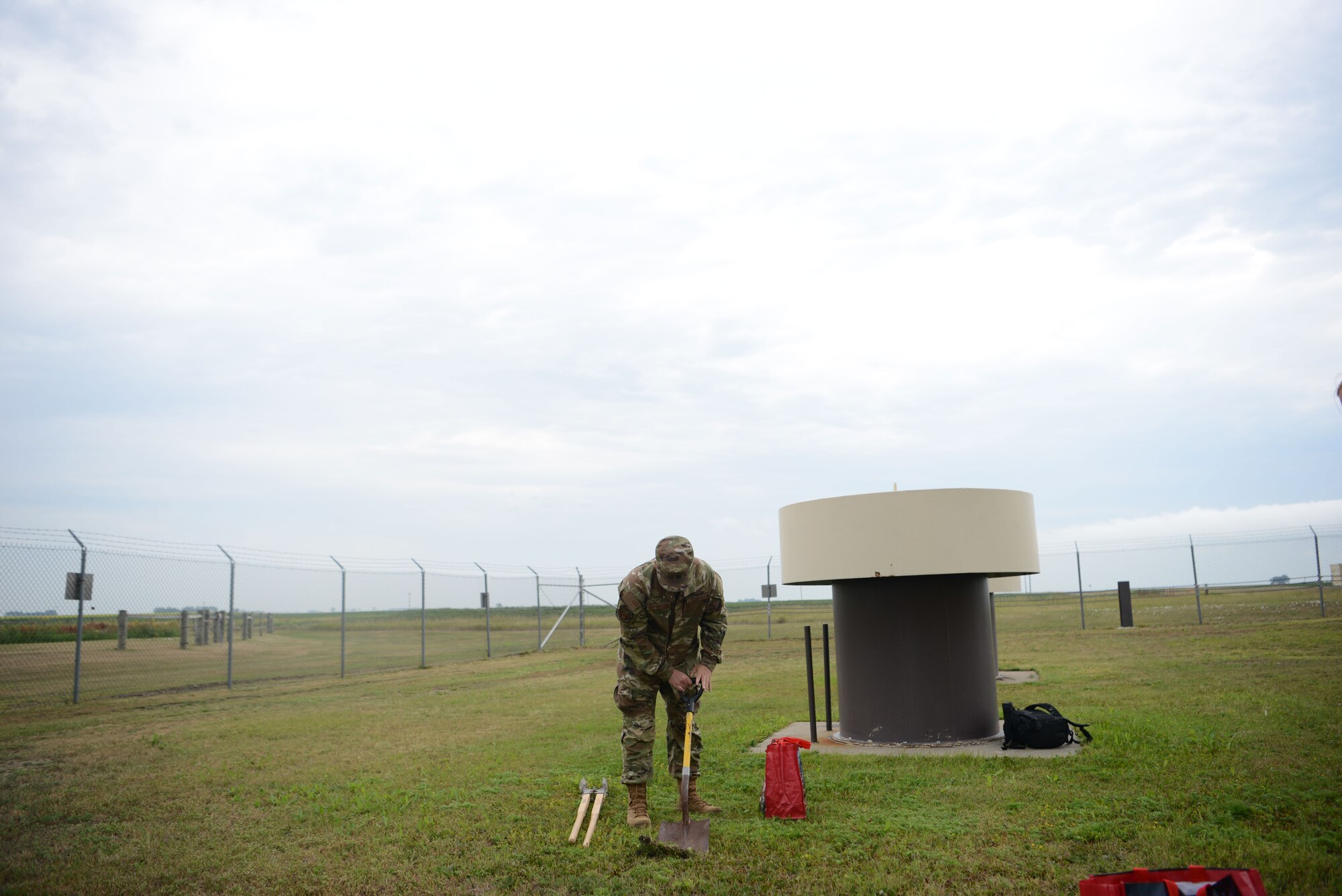 U.S. Air Force Staff Sgt. Oscar Ruiz-Camacho, 5th Operational Medical Readiness Squadron, Bioenvironmental Engineering Technician, digs a hole outside of a missile alert facility (MAF), near Minot Air Force Base, North Dakota, July 25, 2023. Ruiz-Camacho collected a soil sample at a MAF to test for organic phosphates from pesticides. Airmen from the 5th OMRS and the United States Air Force School of Aerospace Medicine visited Minot’s MAFs as part of the ongoing “Missile Community Cancer Study” at all three intercontinental ballistic missile wings in Air Force Global Strike Command. The team assessed indoor air quality at each facility to include temperature, humidity, carbon dioxide and carbon monoxide levels. They also collected water and soil samples and tested for presence of radon, polychlorinated biphenyls, organic phosphates and other potential occupational exposure hazards. USAFSAM is part of the Air Force Research Laboratory’s 711th Human Performance Wing.