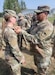 Master Sgt. Aquanita Burras presents 1st Lt. Katy Voss with the Norwegian Foot March badge. Voss recently completed a Norwegian Foot March competition July 25 in Romania, and her team of 405th Army Field Support Brigade Logistics Civil Augmentation Program professionals said they’re very proud of her accomplishment. (U.S. Army courtesy photo)