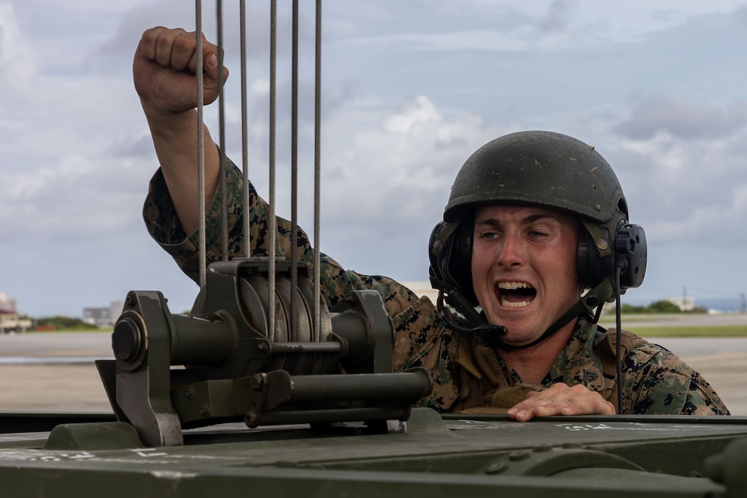 U.S. Marine Corps Cpl. Jacob Beard, a High Mobility Artillery Rocket System operator with 3rd Battalion, 12th Marines, assists Marine Medium Tiltrotor Squadron (VMM) 265, 1st Marine Aircraft Wing in the test of a prototype HIMARS loading system, which allows the HIMARS launch pod to be loaded into the back of an MV-22B Osprey, at Marine Corps Air Station Futenma, Okinawa, Japan, July 26, 2023. The system was designed by GySgt. Rodrigo HernandezPolindara, VMM-265, to offer a more efficient method of transporting HIMARS.