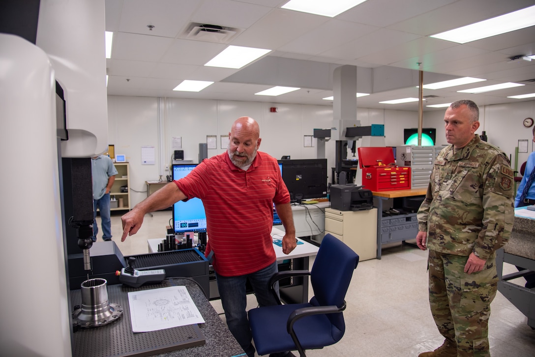 Two men look at a machine in a lab.