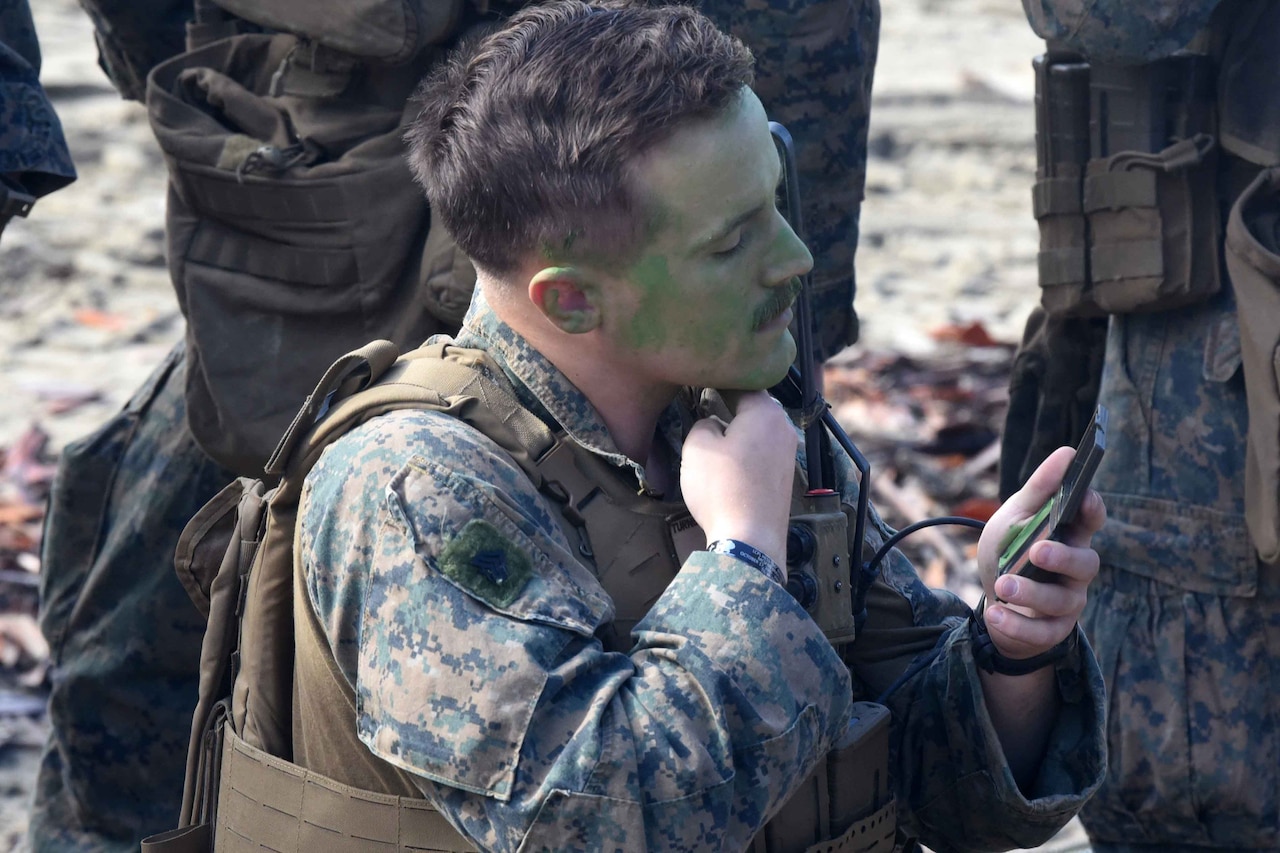 A Marine applies camouflage.