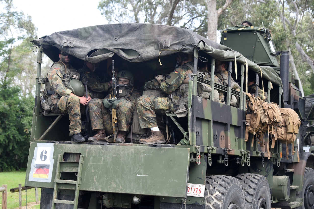 Troops ride in a military truck.