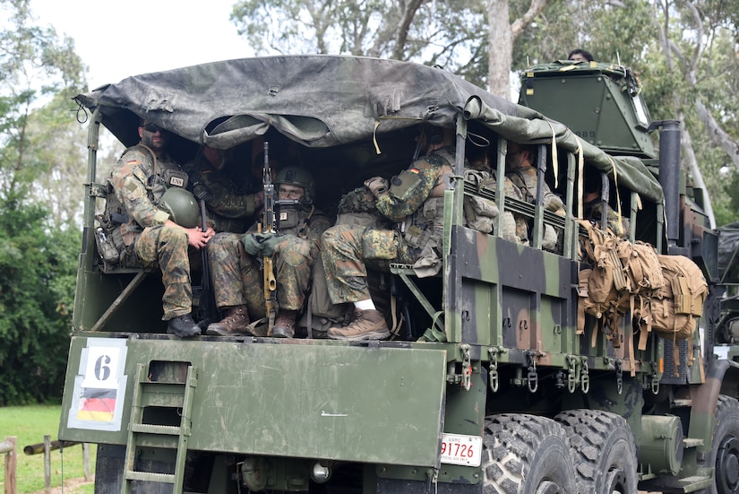 Troops ride in a military truck.