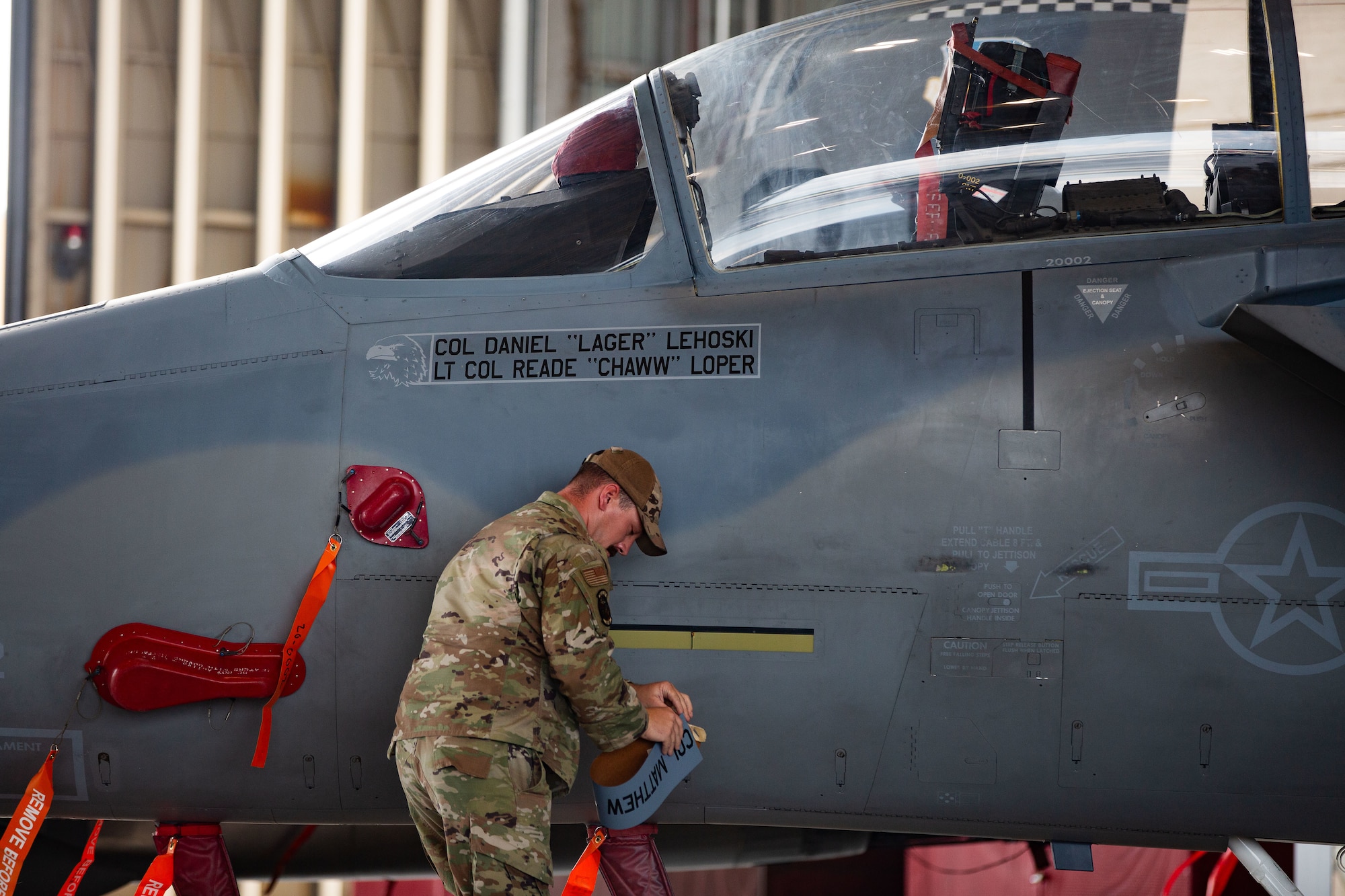 Senior Airman Adam Roach, 96th Aircraft Maintenance Squadron F-15EX Dedicated Crew Chief, unveils Col. Daniel Lehoski's name on the 53rd Wing's flagship F-15EX2 during the 53rd Wing Change of Command ceremony July 21 at Eglin Air Force Base, Fla. Before taking command of the 53rd, Lehoski served as the Commandant of the U.S. Air Force Weapons School at Nellis Air Force Base, Nev. where he oversaw the training of expert tactical instructors and leaders focused on air, space, and cyber on behalf of the joint force. (U.S. Air Force photo by Mr. Dave Shelikoff)