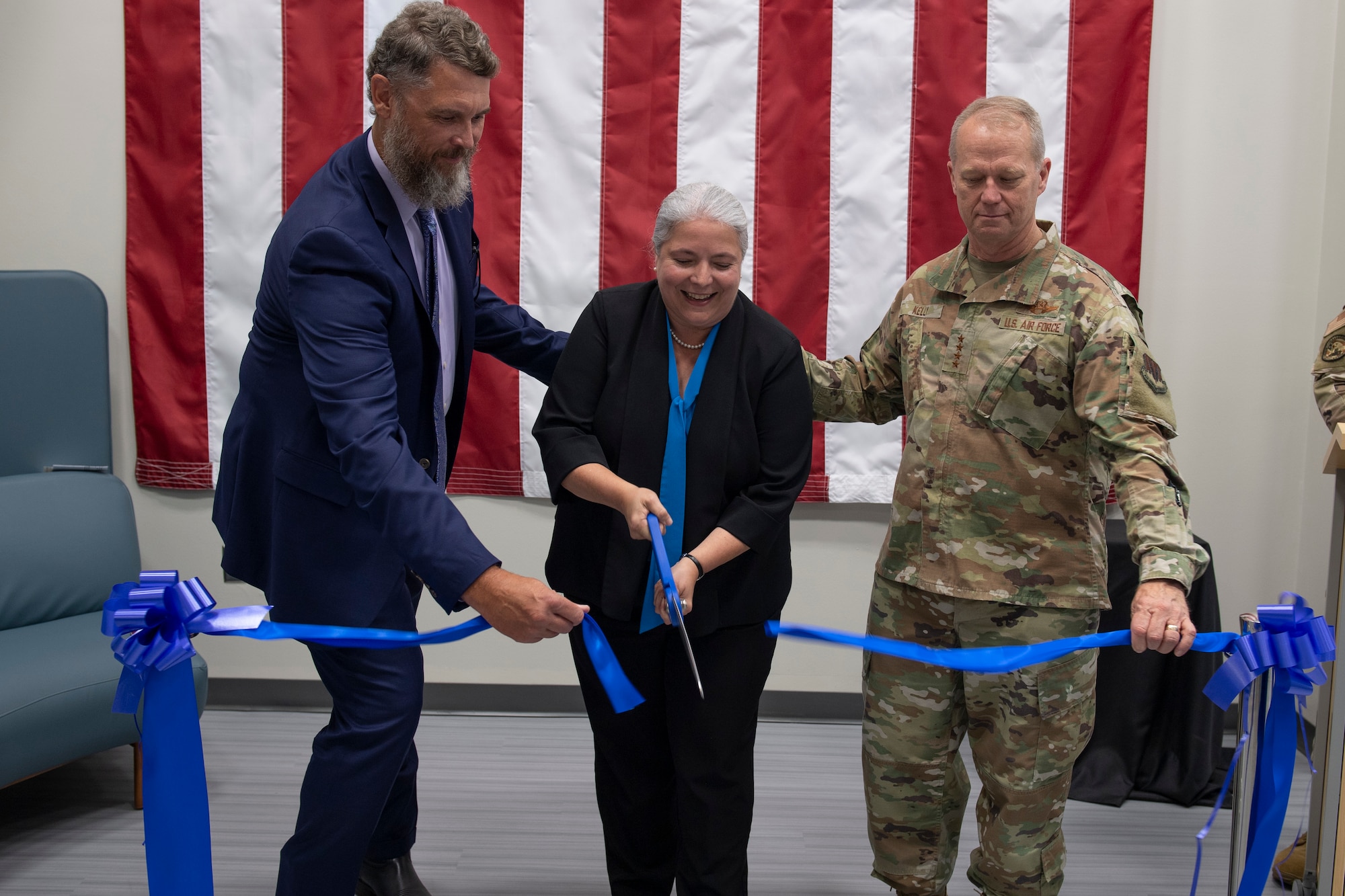 U.S. Air Force Gen. Mark Kelly, commander Air Combat Command, right, and Shane Hamilton, ACC Intelligence associate director, left, hold a ribbon for Cristina Stone, ACC Intelligence Data and Technology Futures technical advisor, during the grand opening of the new data lab, nicknamed the BRBR Shop, from its barbershop origins, for Better Research Better Results, at Langley Air Force Base, Virginia, July 20, 2023. The data lab allows intelligence Airmen Wi-Fi internet access to leverage open-source code and tools. (U.S. Air Force photo by Tech. Sgt. Joshua Edwards)
