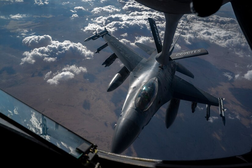 A boom is lowered to a fighter jet so it can be refueled.
