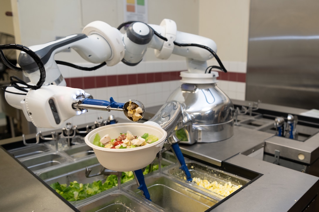 “Alfred,” an automated food preparation robot, prepares a salad at the Monarch Dining Facility, at Travis Air Force Base, California, Dec. 9, 2021. Travis AFB is the first military base to utilize and test “Alfred.” The design is meant to increase productivity, reduce food waste, and lower risks of viral and microbial transmissions. (U.S. Air Force photo by Chustine Minoda)