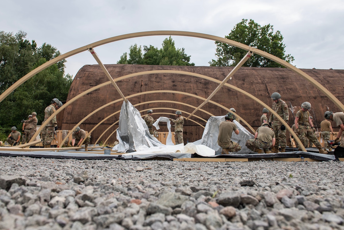 Multiple Airmen set up a tent