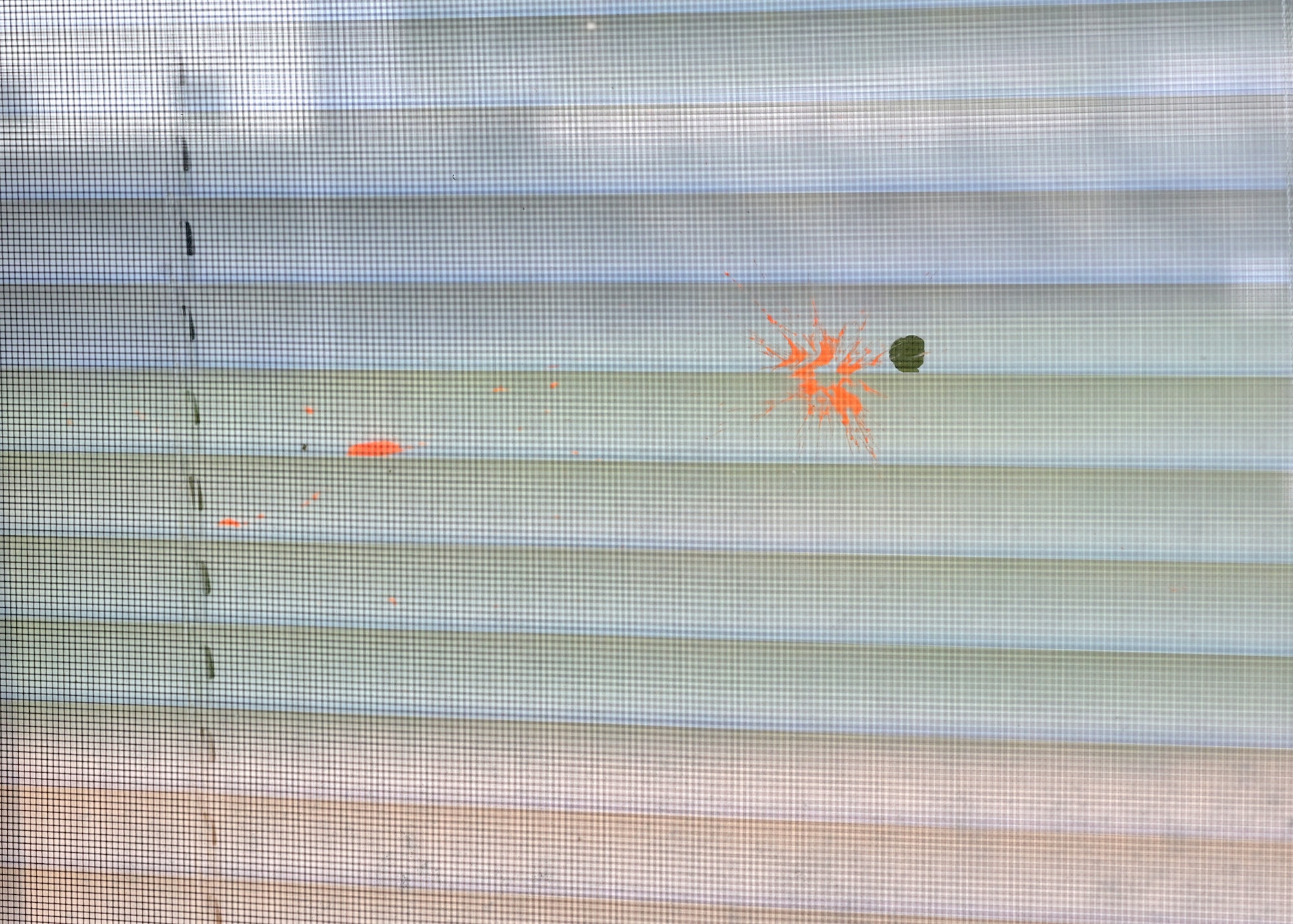 A simunition round explodes against the window of a high school classroom.
