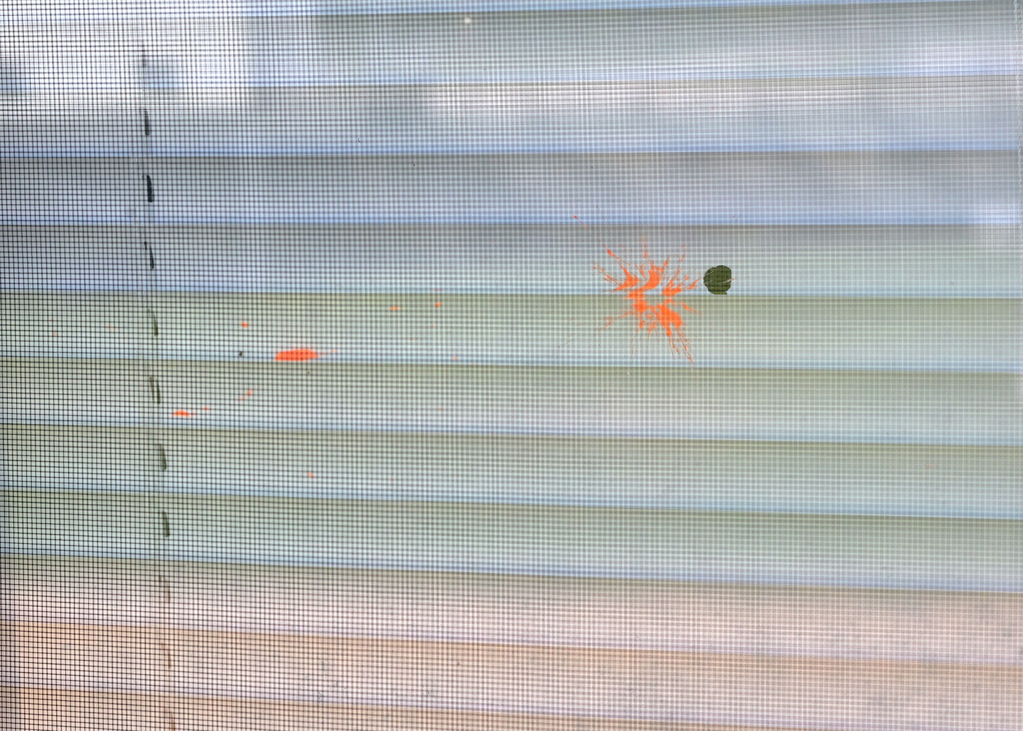 A simunition round explodes against the window of a high school classroom.