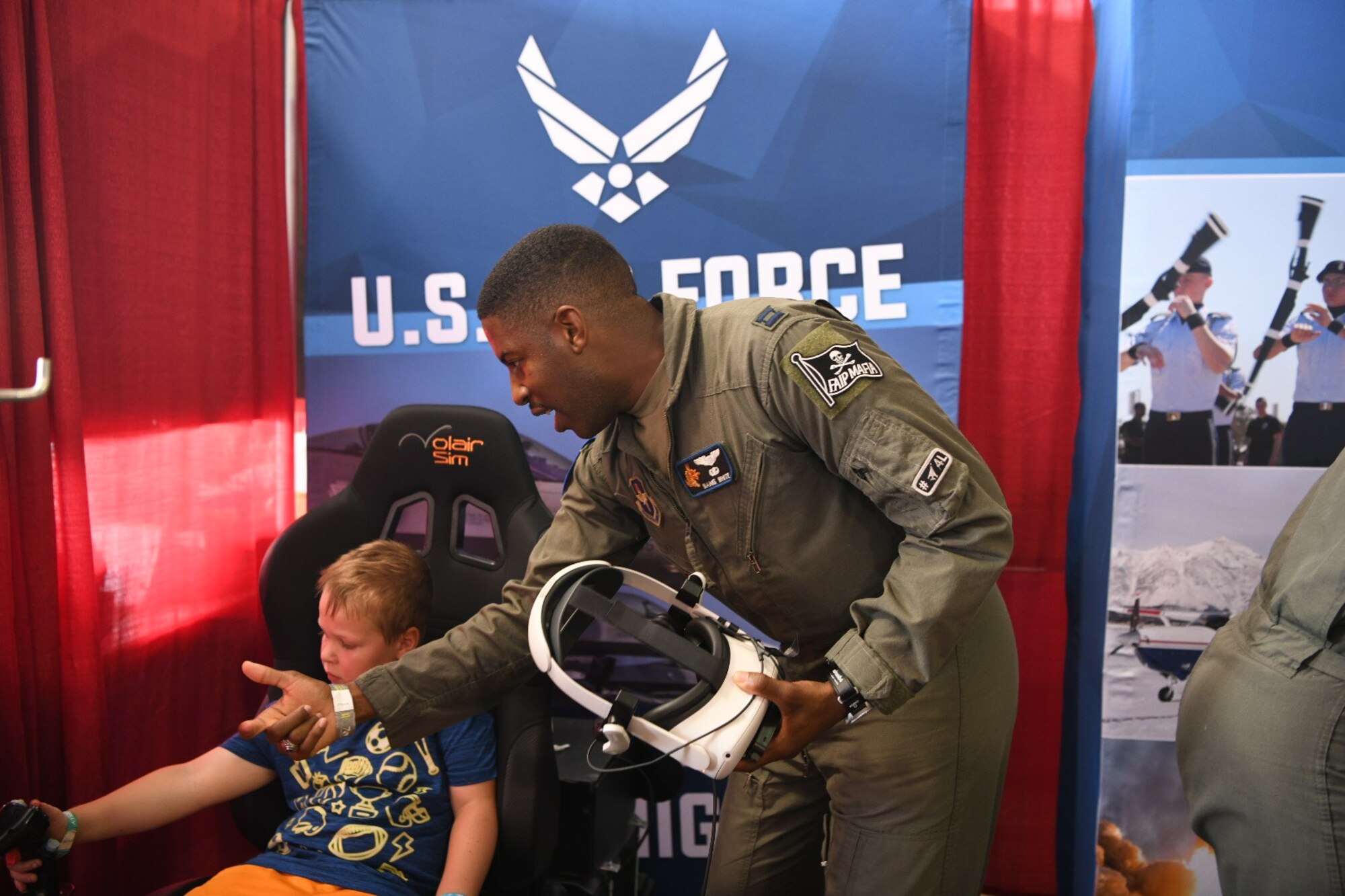 Aviation Inspiration Mentorship volunteers from Air Education and Training Command intact with attendees of KidsVenture at Experimental Aircraft Association Oshkosh AirVenture in Oshkosh, Wisconsin, July 27.