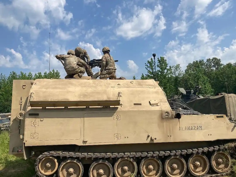 Soldiers with Alpha Battery, 2nd Battalion, 138th Field Artillery, mount a M240 machine gun on top of their M992 ammunition supply vehicle during their first stage of the Top Gun competition at Fort Chaffee, Arkansas, June 28, 2023