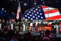 man wearing army uniform waves a flag on stage
